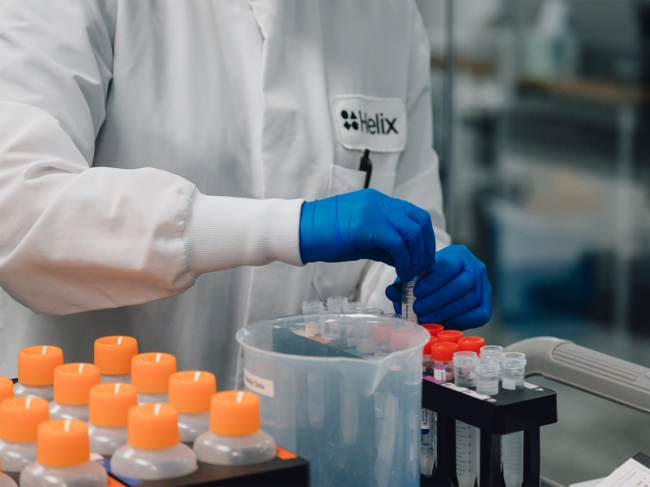 Helix employee in lab with testing tubes