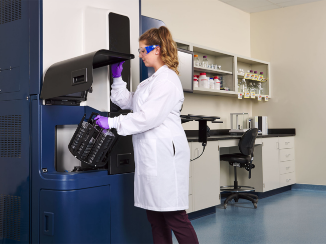 Quality control specialist loading multiple sample cartridges into the Rapid Micro Biosystems Growth Direct instrument 