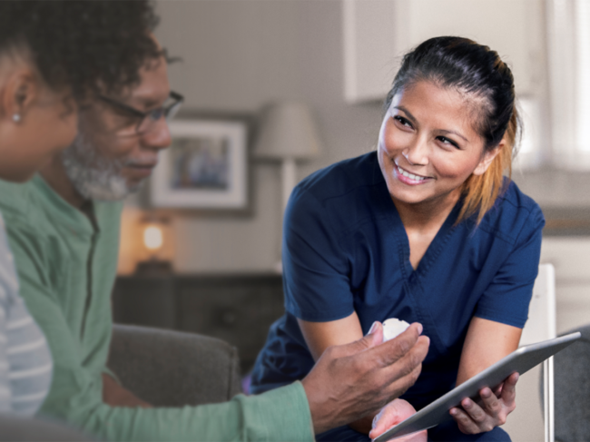 Nurse holds Ipad with elderly patients