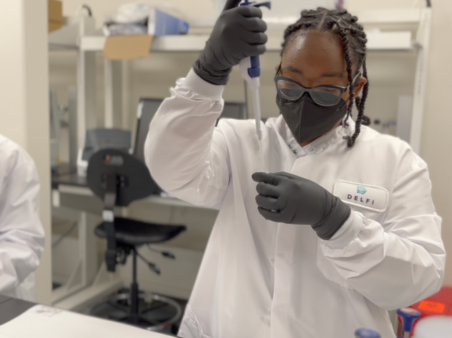 Delfi employee pipetting in the lab