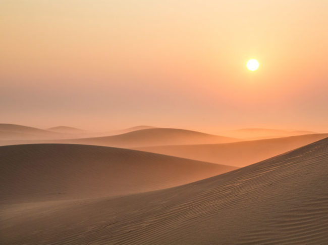 Sunrise in a desert with sand dunes