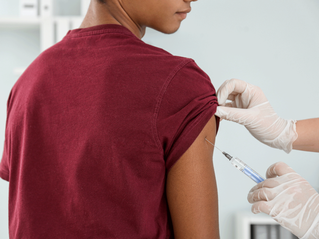 Teen receiving vaccine