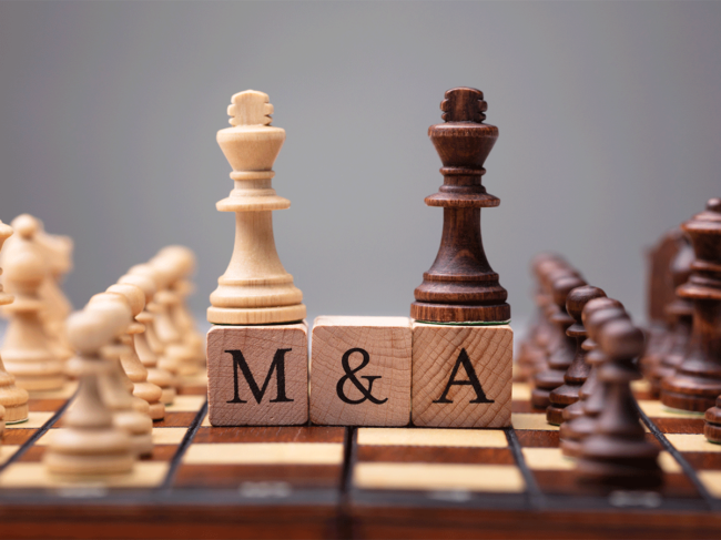 Chess board and pieces, blocks spelling out M&A