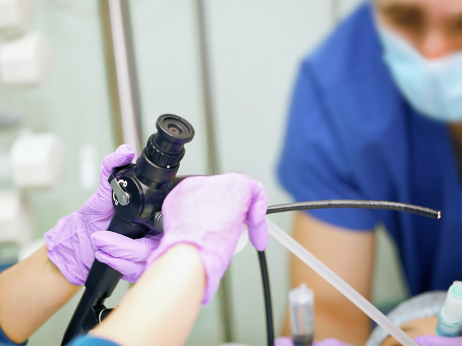 Male nurse assists the female doctor during bronchoscope procedure