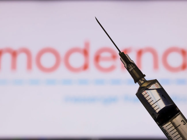 Syringe in front of Moderna logo