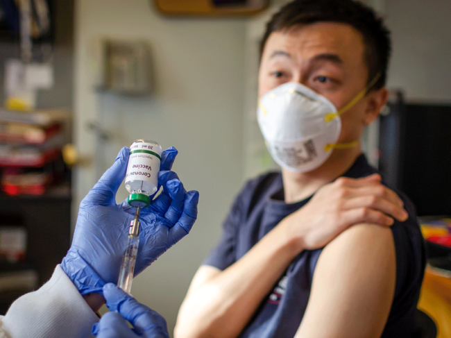 Man wearing mask, receiving coronavirus vaccine