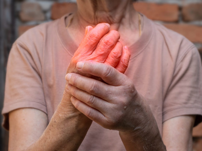 Photo of older woman holding hand that's colored red