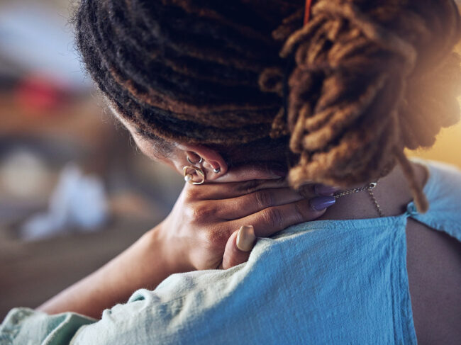 Woman holding neck in pain