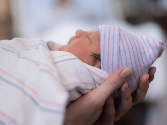 Photo of hands holding a baby 