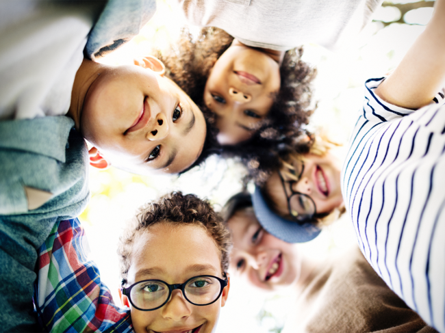 Group of kids, faces huddled together