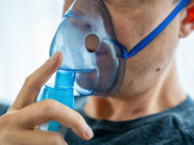 Close up of man wearing nebulizer